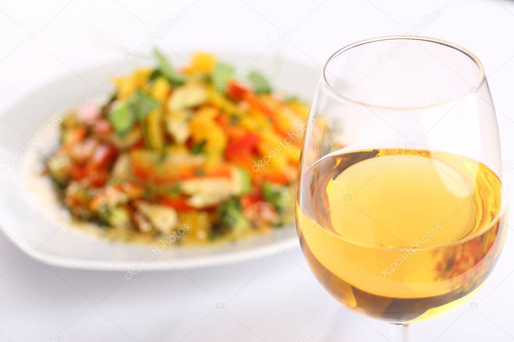 White wine glass and food background, vegetable salad