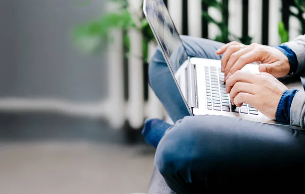 Mãos Masculinas Digitando Laptop Colocado Cima Das Pernas Cruzadas Casa — Fotografia de Stock