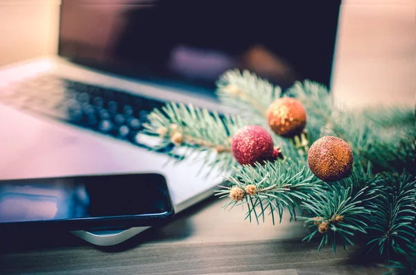 Noel dekorasyon - köknar ve parlak topları dizüstü bilgisayar ve cep telefonu ile bir ofis masasında