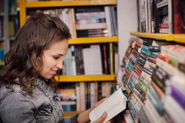 Γυναίκα μαθητής που διαλέγει ένα βιβλίο στο βιβλιοπωλείο. — Φωτογραφία Αρχείου