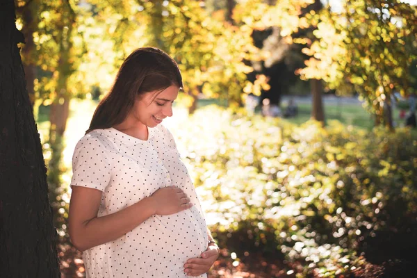 日当たりの良い公園で妊娠中の女性 — ストック写真