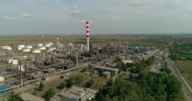 Petrol rafinerisi. Tanklar, yollar. Uçak atış. Kamera baca doğru yayılıyor. 50fps