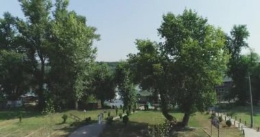 Kamera bir Parkı'ndan yükselir ve nehrin karşısına gider.