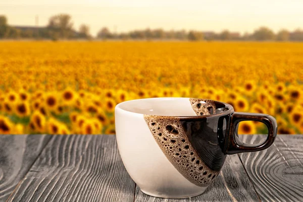 coffee cup on the background of the field with sunflowers
