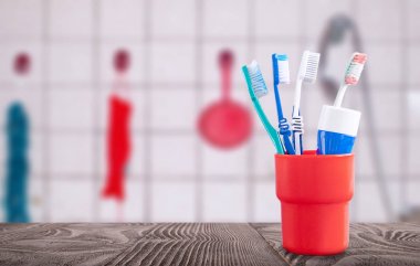 Ahşap bir yüzey üzerinde diş fırçası ve diş macunu ile kırmızı konteyner