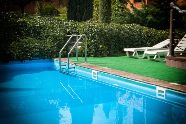 Piscina privada con piedras perimetrales y escalones para descender — Foto de Stock