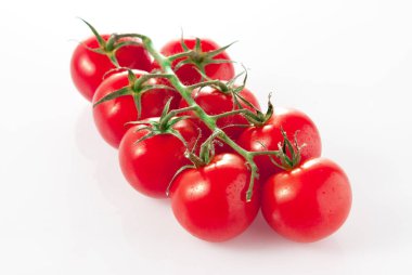 Beyaz arka planda yeşil saplı kırmızı domatesler. Yiyecek ve içecek konsepti.