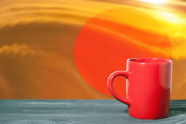 赤い円の背景にテーブルの表面に赤いマグカップ 飲み物のコンセプト — ストック写真