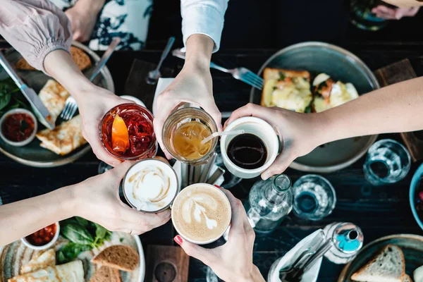 people toasting with different drinks, top view