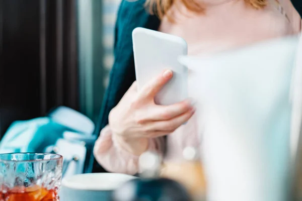 young woman holding smartphone in restaurant