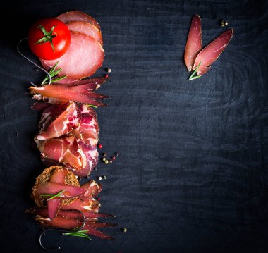 Çiğ füme et farklı türleri kümesi. Jamon Lomo, oppa ve siyah bir zemin üzerine fileto. 