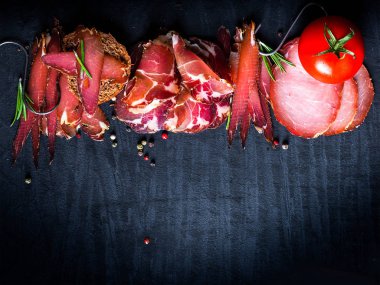 Çiğ füme et farklı türleri kümesi. Jamon Lomo, oppa ve siyah bir zemin üzerine fileto. 