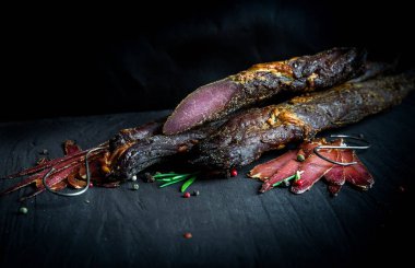 Çiğ füme et farklı türleri kümesi. Jamon Lomo, oppa ve siyah bir zemin üzerine fileto. 