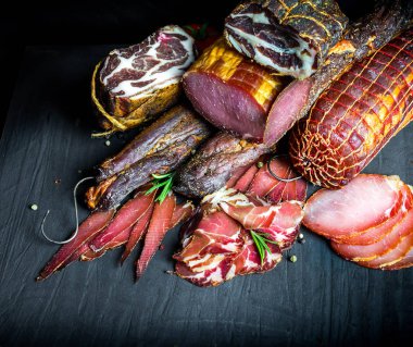 Çiğ füme et farklı türleri kümesi. Jamon Lomo, oppa ve siyah bir zemin üzerine fileto. 