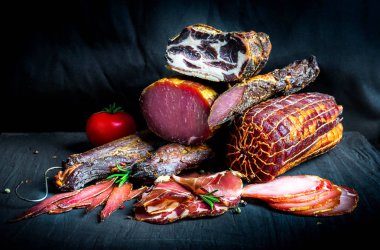 Çiğ füme et farklı türleri kümesi. Jamon Lomo, oppa ve siyah bir zemin üzerine fileto. 