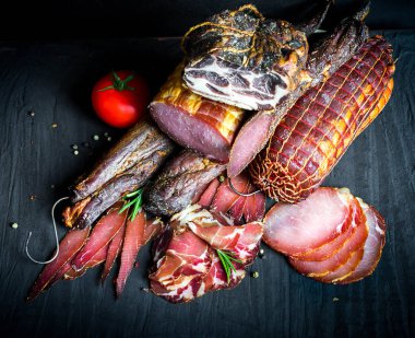 Çiğ füme et farklı türleri kümesi. Jamon Lomo, oppa ve siyah bir zemin üzerine fileto. 