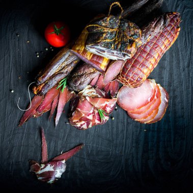 Çiğ füme et farklı türleri kümesi. Jamon Lomo, oppa ve siyah bir zemin üzerine fileto. 
