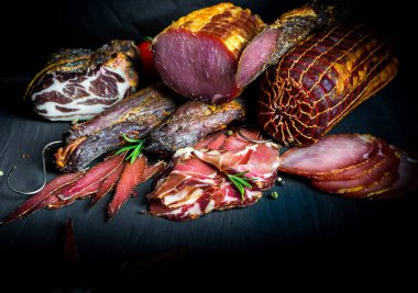 Çiğ füme et farklı türleri kümesi. Jamon Lomo, oppa ve siyah bir zemin üzerine fileto. 