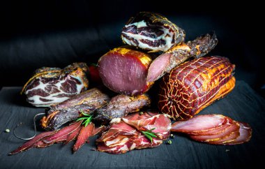 Çiğ füme et farklı türleri kümesi. Jamon Lomo, oppa ve siyah bir zemin üzerine fileto. 