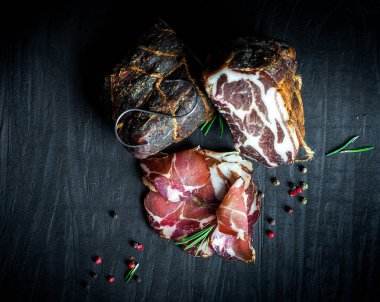 Çiğ füme et farklı türleri kümesi. Jamon Lomo, oppa ve siyah bir zemin üzerine fileto. 