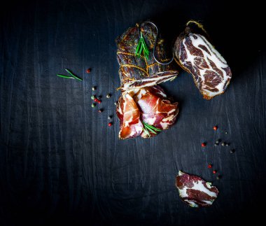 Çiğ füme et farklı türleri kümesi. Jamon Lomo, oppa ve siyah bir zemin üzerine fileto. 