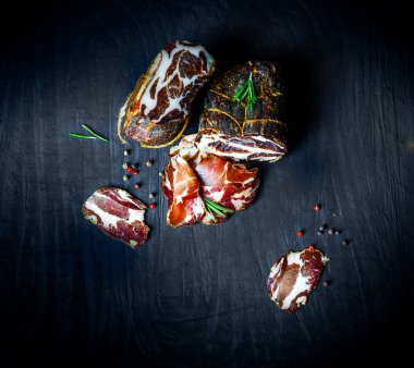 Çiğ füme et farklı türleri kümesi. Jamon Lomo, oppa ve siyah bir zemin üzerine fileto. 