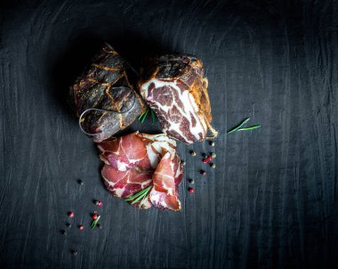 Çiğ füme et farklı türleri kümesi. Jamon Lomo, oppa ve siyah bir zemin üzerine fileto. 