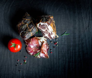Çiğ füme et farklı türleri kümesi. Jamon Lomo, oppa ve siyah bir zemin üzerine fileto. 