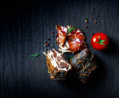 Çiğ füme et farklı türleri kümesi. Jamon Lomo, oppa ve siyah bir zemin üzerine fileto. 