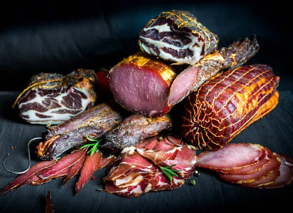 Çiğ füme et farklı türleri kümesi. Jamon Lomo, oppa ve siyah bir zemin üzerine fileto. 