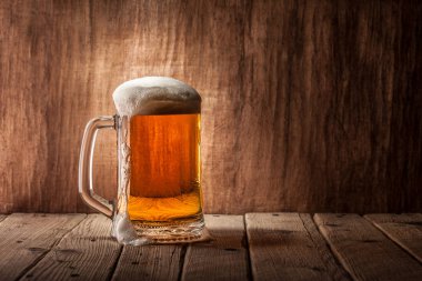 Bira ahşap arka plan üzerinde köpük bardak