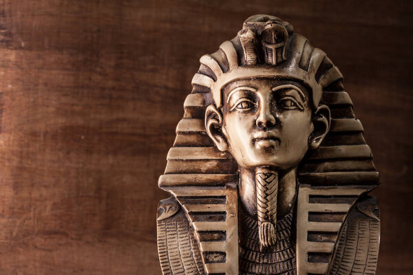 Stone pharaoh Tutankhamen mask on dark background