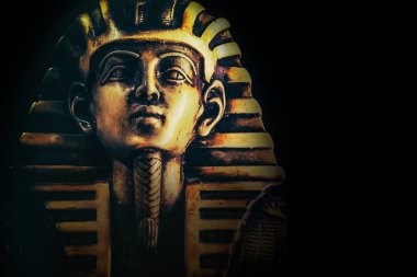 Stone pharaoh Tutankhamen mask on dark background clipart