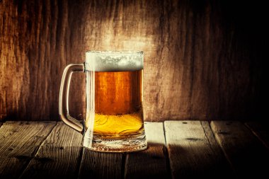 Bira ahşap arka plan üzerinde köpük bardak