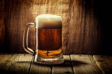 Bira ahşap arka plan üzerinde köpük bardak