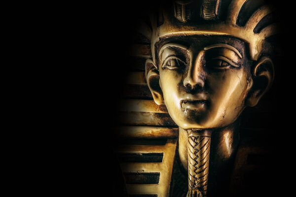 Stone pharaoh Tutankhamen mask on dark background