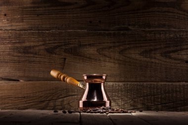 kahve çekirdekleri ve bakır kahve Türk ahşap arka plan üzerinde dağınık