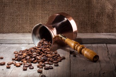 kahve çekirdekleri ve bakır kahve Türk ahşap arka plan üzerinde dağınık