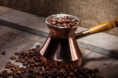 kahve çekirdekleri ve bakır kahve Türk ahşap arka plan üzerinde dağınık