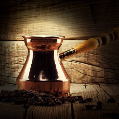 kahve çekirdekleri ve bakır kahve Türk ahşap arka plan üzerinde dağınık