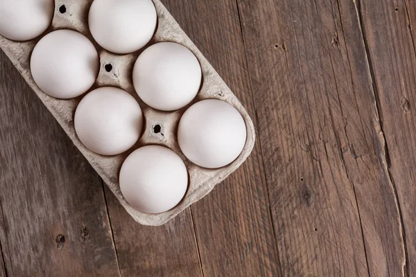 Белые Сырые Яйца Упаковке Деревянном Фоне Вид Сверху — стоковое фото