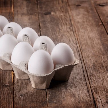 Pack ahşap arka plan, üstten görünüm üzerinde beyaz çiğ yumurta