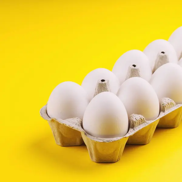 Weiße Rohe Eier Packung Auf Gelbem Hintergrund Nahaufnahme — Stockfoto