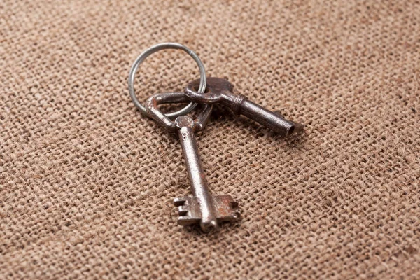两个老锈密钥在质朴的麻布背景 — 图库照片