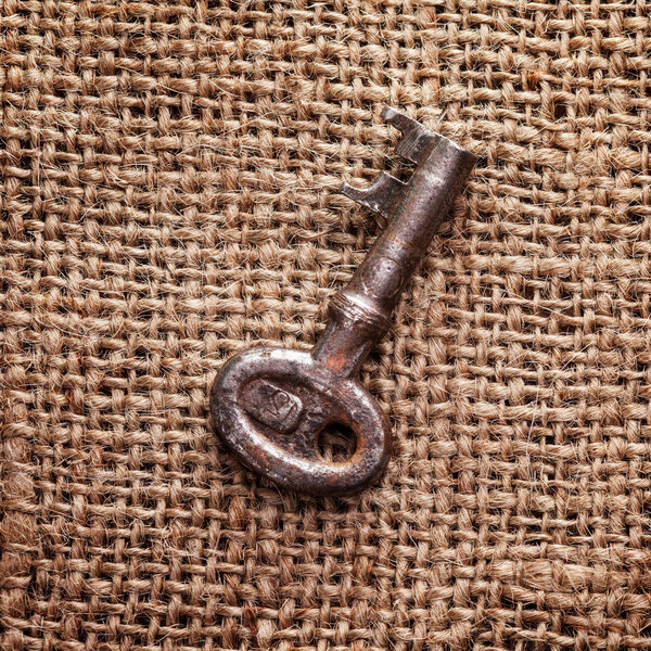 old key on rustic sackcloth background, close up