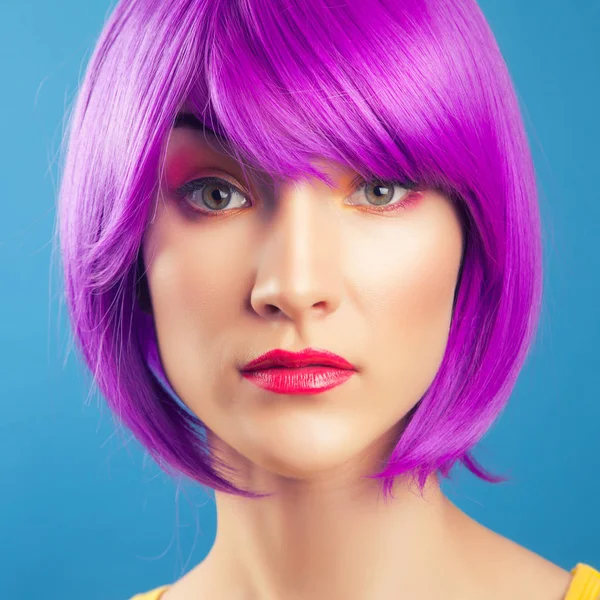 beautiful woman wearing colorful wig against blue background