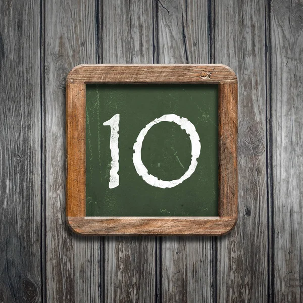 数字10在绿色黑板在木背景之上 — 图库照片