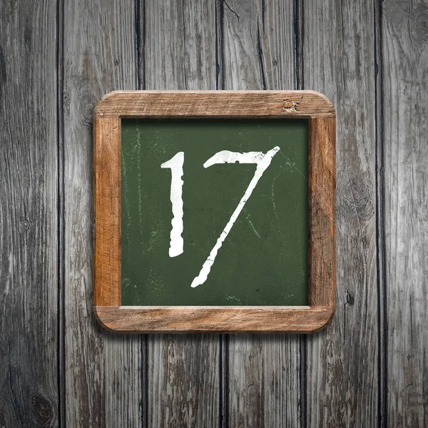 数字17在绿色黑板在木背景之上 — 图库照片