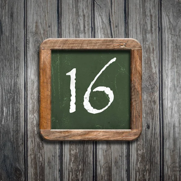 数字16在绿色黑板在木背景之上 — 图库照片