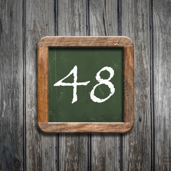 数字48在绿色黑板在木背景之上 — 图库照片
